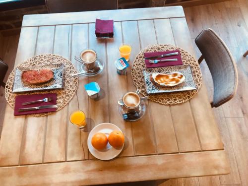 a table with two plates of food and oranges on it at Hostal O Portiño in Rianjo