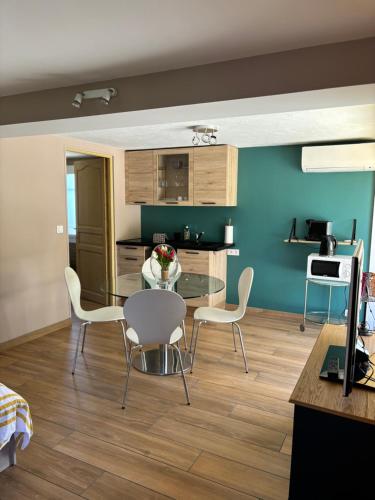 une cuisine et une salle à manger avec une table et des chaises dans l'établissement Studio indépendant cosy, à Fréjus