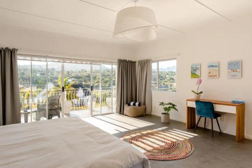 a bedroom with a bed and a desk with a desk at The Views Guesthouse in Somerset West