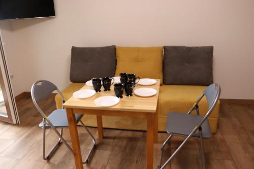 a table and chairs in a living room with a couch at Apartamenty Zator Energy Rest in Zator