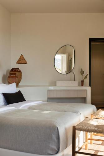 a bedroom with a large bed and a mirror at Porto Mykonos in Mýkonos City