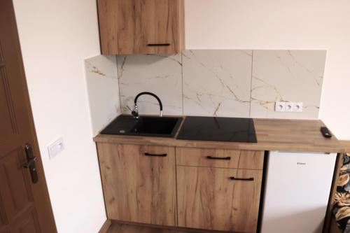 a small kitchen with a sink and a refrigerator at Apartamenty Zator Energy Rest in Zator