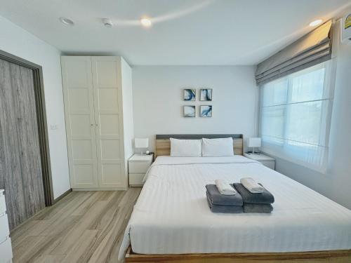 1 dormitorio con 1 cama grande y 2 toallas. en The Title Residences, Naiyang Beach, Phuket en Nai Yang Beach