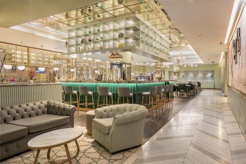 a restaurant with a bar with couches and chairs at The Emerald House Lisbon - Curio Collection By Hilton in Lisbon