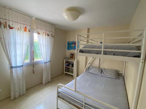 1 dormitorio con 2 literas y ventana en Bajo con Jardin y Piscina!, en Galizano