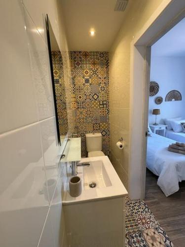 a bathroom with a sink and a tub and a bed at Casa Nova Vida in Paderne