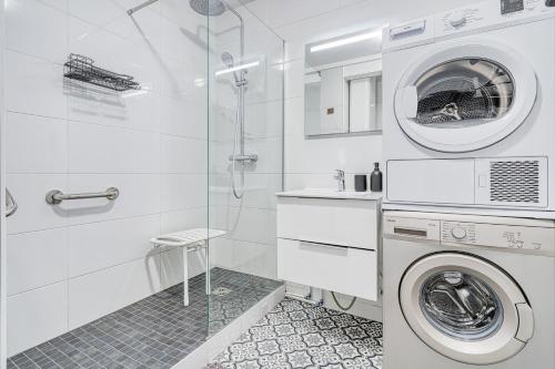 La salle de bains est pourvue d'un lave-linge et d'une douche. dans l'établissement Le Paisible - Aux portes de Paris - 316B, à Rueil-Malmaison