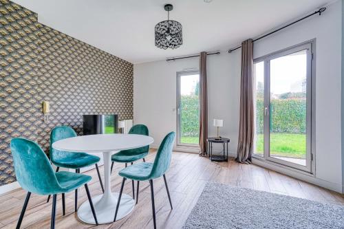 une salle à manger avec une table et des chaises vertes dans l'établissement Le Paisible - Aux portes de Paris - 316B, à Rueil-Malmaison