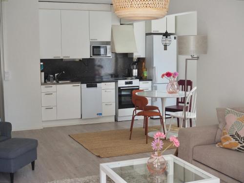 a living room with a table and a kitchen at Cozy two-room condo with private balcony in Helsinki