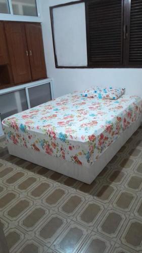 a bed in a room with flowers on it at Conceitual Hostel Natal in Natal