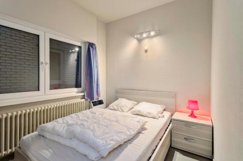 a bedroom with a white bed and a window at Nenuphars Glvls in Wenduine
