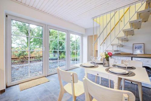 a dining room with a table and chairs and windows at De Strandloper in Westerdeichstrich