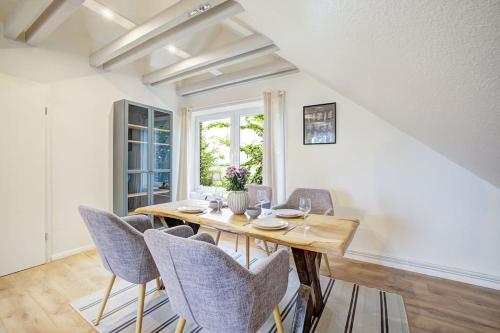 a dining room with a wooden table and chairs at De Strandloper in Westerdeichstrich
