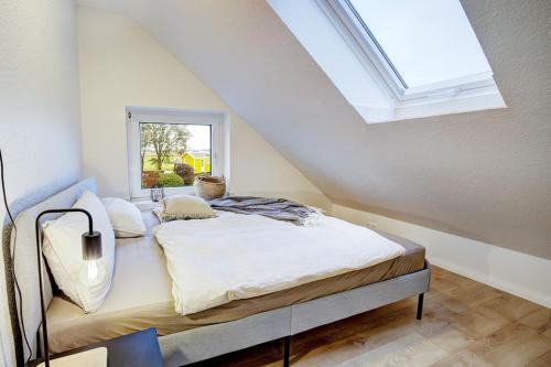 a bedroom with a bed with a skylight at De Strandloper in Westerdeichstrich