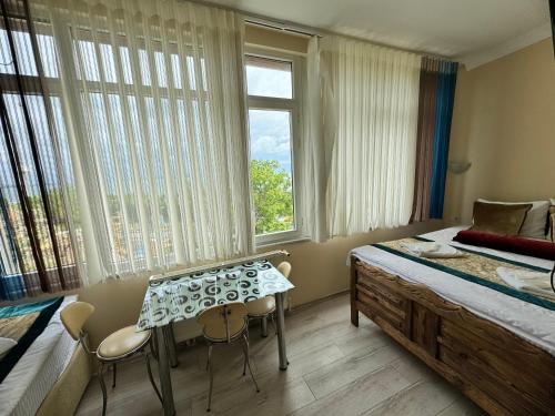 een slaapkamer met een bed en een tafel en ramen bij Happy Suite Boutique Hotel in Istanbul