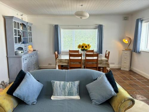ein Wohnzimmer mit einem blauen Sofa und einem Tisch in der Unterkunft Beachcomber Cottages in Ballyconneely