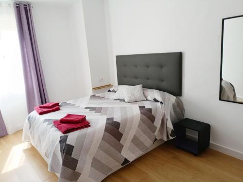 a bedroom with a bed with red towels on it at Casa Encanto Consuegra in Consuegra