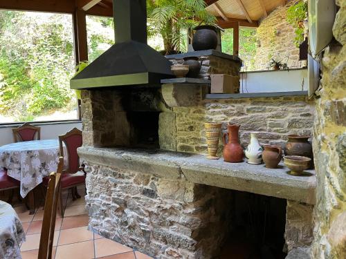 un forno in mattoni all'aperto con vasi e vasi sopra di Casa Rural O Vilar a Mera de arriba