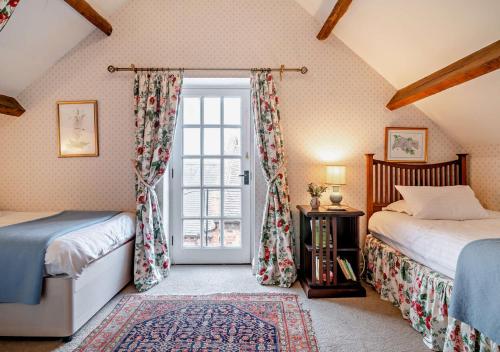 sypialnia z 2 łóżkami i oknem w obiekcie Cottage at Hill Farm w mieście Wichenford
