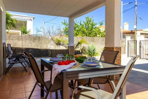 a table with a bowl of tomatoes on a patio at Chalet OLIVA NOVA in Oliva