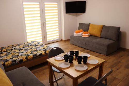 a living room with a couch and a table at Apartamenty Zator Energy Rest in Zator