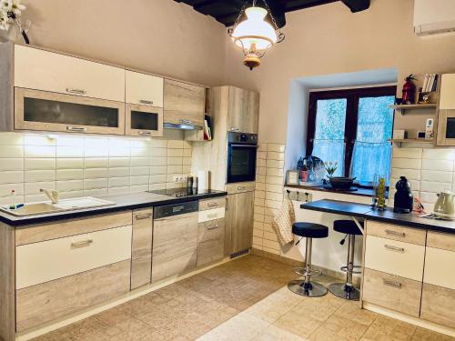 a kitchen with white cabinets and a sink and a counter at Búj-Lak Vendégház in Zalaszentmárton