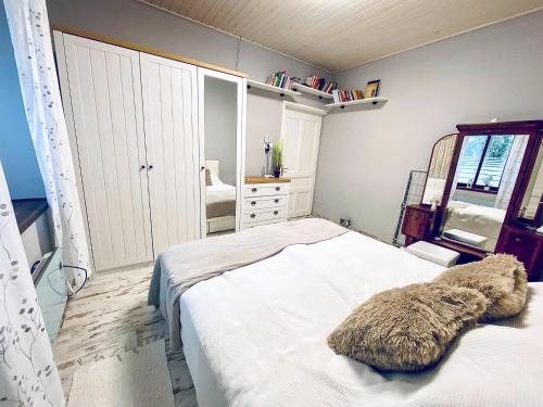a bedroom with a white bed and a mirror at Búj-Lak Vendégház in Zalaszentmárton