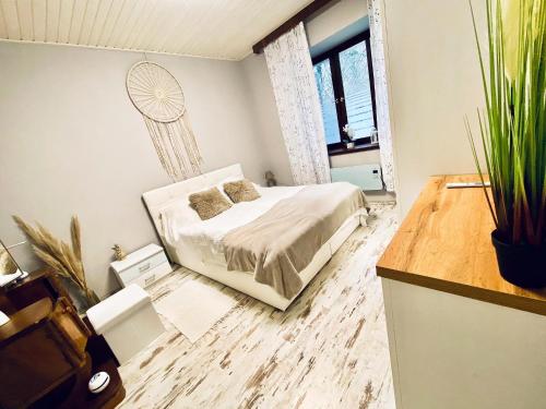 a bedroom with a bed and a potted plant at Búj-Lak Vendégház in Zalaszentmárton