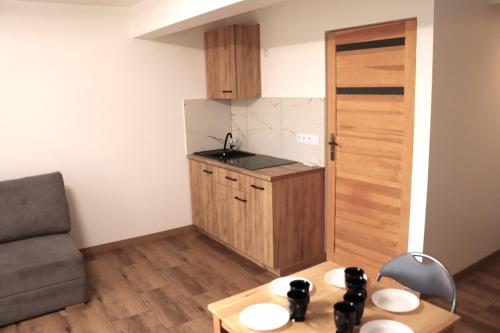 a small kitchen with a table and a couch at Apartamenty Zator Energy Rest in Zator