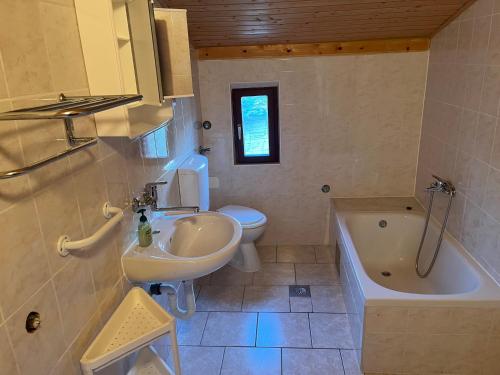 ein Badezimmer mit Waschbecken, Toilette und Badewanne in der Unterkunft SunsetBeach in Grebaštica