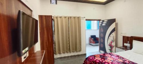 Ayodhya的住宿－Goroomgo The Ram Krishna Palace Ayodhya - Luxury Room，一间卧室配有一张床和一台电视。
