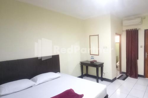 En eller flere senger på et rom på Hotel Palem 2 Syariah Malang Redpartner
