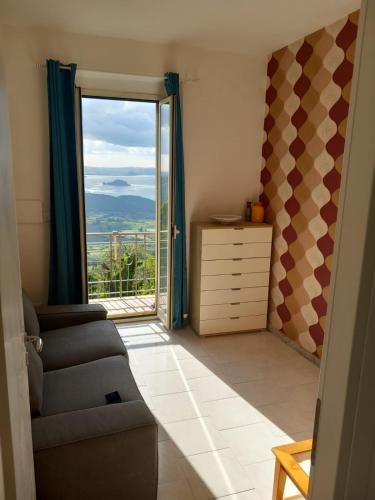 a living room with a couch and a large window at Reginella in Montefiascone