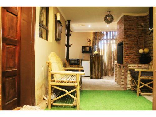 ein Wohnzimmer mit einem grünen Teppich und einem Stuhl in der Unterkunft Peace at Home in Augustinium
