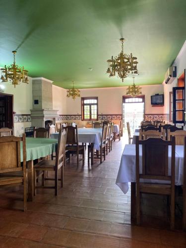 a dining room with tables and chairs and chandeliers at Casa Augusta - QUINTA in Penafiel