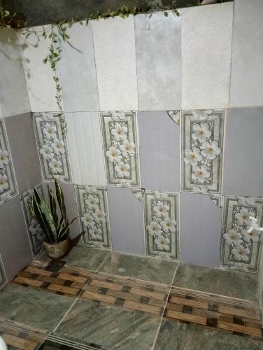 a room with a tile wall with flowers on it at SIGIRI HUNTER'S HOMESTAY & Hostel in Sigiriya