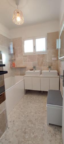 une salle de bain avec deux lavabos et une baignoire et une baignoire dans l'établissement Villa artiste & spiritual, à Aubagne