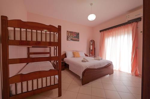 sypialnia z 2 łóżkami piętrowymi i oknem w obiekcie Villa M Cako w mieście Ksamil