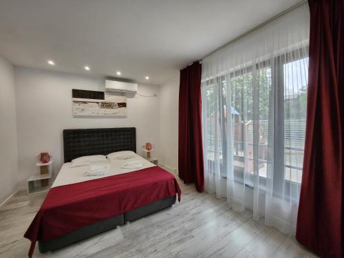 a bedroom with a bed and a large window at Analeya in Eforie Nord