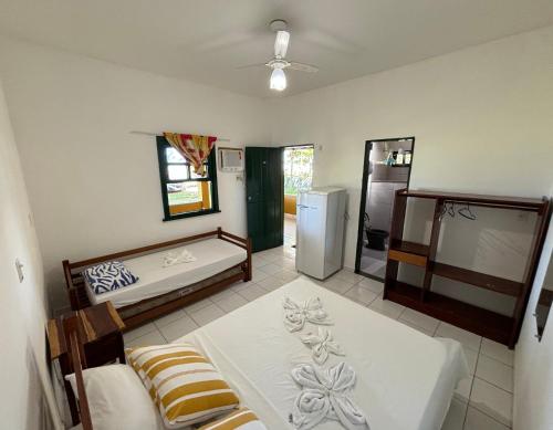 Zimmer mit einer Küche mit einem Kühlschrank und einem Bett in der Unterkunft Pousada Casarão - Pé na Areia Cumuruxatiba in Cumuruxatiba