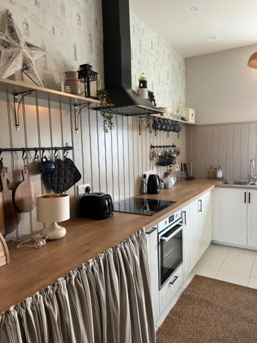 a kitchen with white cabinets and a wooden counter top at Loop Head Lighthouse Attendant's Cottage in Kilbaha