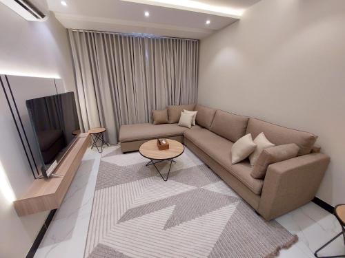 sala de estar con sofá y TV en Elite House, en Taif