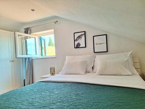 a bedroom with a bed with white sheets and a window at Blue Promenade Apartments in Dubrovnik