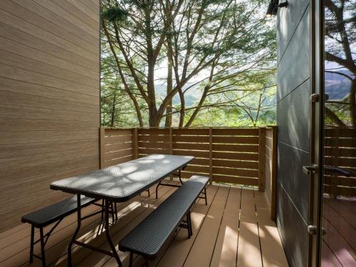 a patio with a table and chairs on a wooden deck at Rakuten STAY VILLA Kinugawa Riverside in Nikko