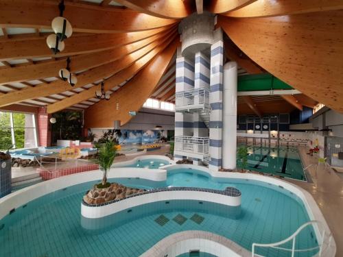 a large swimming pool in a large building at Villa Blue Garden B&B Vlaamse Ardennen nabij Pairi Daiza in Geraardsbergen