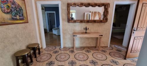 Lyaskovo的住宿－Luxury Villa Bella Lyaskovo Village，浴室设有一张桌子、两张凳子和镜子