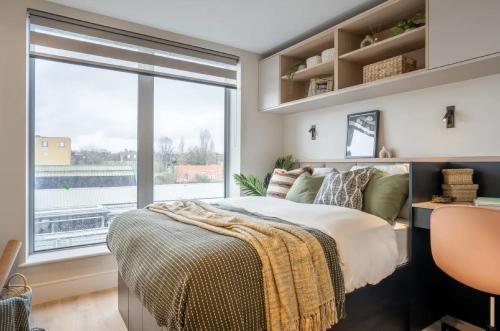 ein Schlafzimmer mit einem Bett und einem großen Fenster in der Unterkunft En-suite room in London