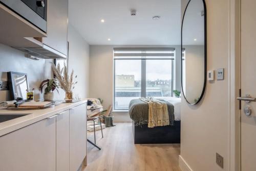 eine Küche und ein Schlafzimmer mit einem Bett in einem Zimmer in der Unterkunft En-suite room in London