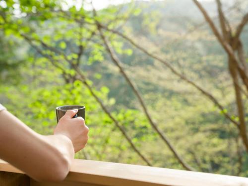 a person holding a wine glass in front of a window at Rakuten STAY VILLA Kinugawa Riverside in Nikko