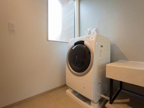 a washing machine in a room next to a table at Rakuten STAY VILLA Kinugawa Riverside in Nikko